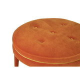 Round footstool upholstered in vibrant orange velvet, featuring a tufted design with visible buttons and a smooth, rounded top. The footstool has a simple, elegant base that complements its plush appearance