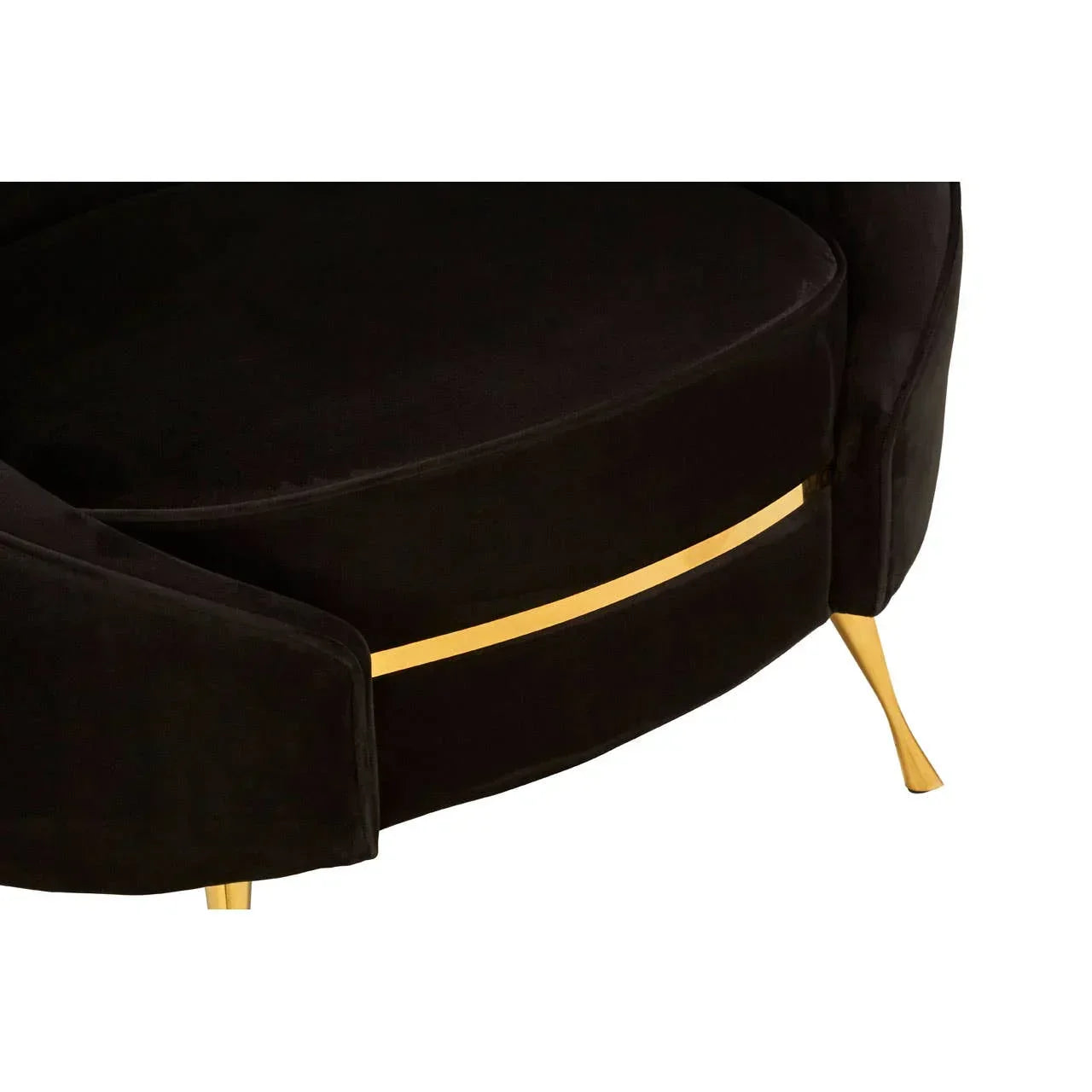 Black velvet sofa seat with gold metal trim and gold tapered legs, close-up view