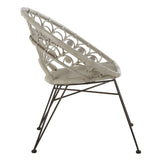 A grey natural rattan chair with a unique open-weave design, featuring a curved backrest and a sleek metal frame with slender legs. The chair is positioned at an angle, showcasing its modern aesthetic and comfortable seating