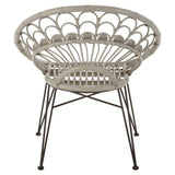 A round, grey natural rattan chair with a woven design and slender metal legs, showcasing a modern and airy aesthetic suitable for indoor or outdoor use