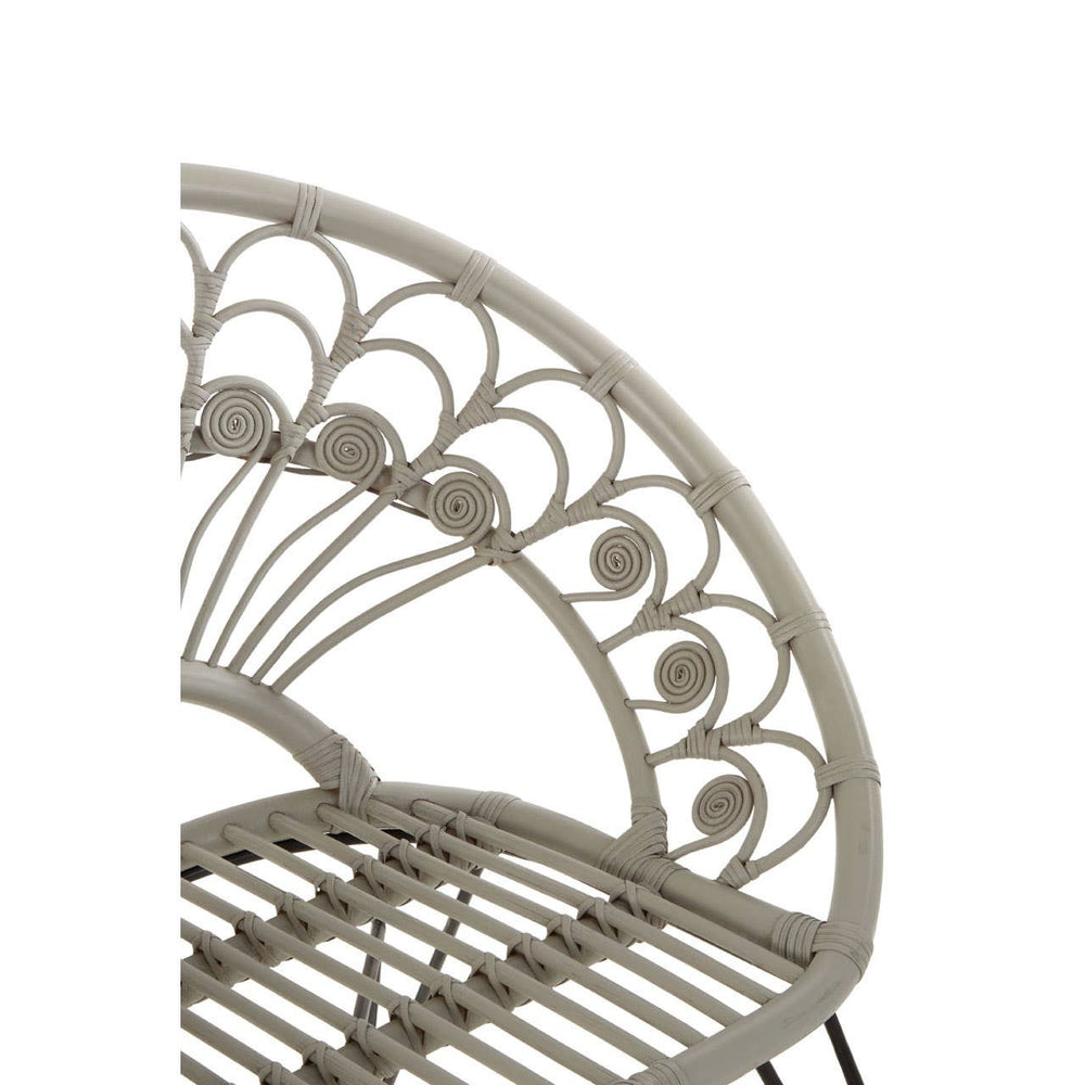 A close-up view of the backrest of the Manado Grey Natural Rattan Chair, showcasing a decorative pattern with curved lines and circular accents, made from natural rattan material. The chair features a sturdy frame and a slatted seat design