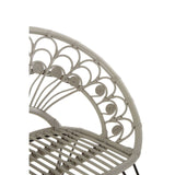 A close-up view of the backrest of the Manado Grey Natural Rattan Chair, showcasing a decorative pattern with curved lines and circular accents, made from natural rattan material. The chair features a sturdy frame and a slatted seat design