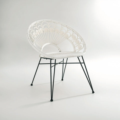 A stylish white rattan chair with a curved backrest and a natural woven texture, supported by sleek black metal legs, set against a light gray background