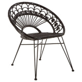 A black natural rattan chair with a curved backrest featuring a fan-like design, supported by slender metal legs. The seat is round and open, showcasing the intricate weaving of the rattan material