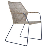 A natural rattan chair with an angled design, featuring a light brown woven seat and backrest supported by a sleek metal frame with a minimalist aesthetic. The chair has a contemporary look, suitable for modern home decor