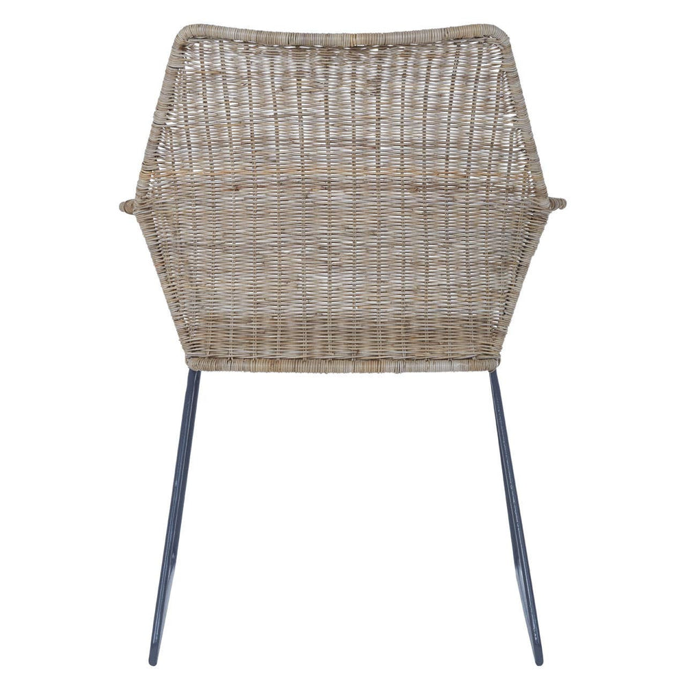 Natural rattan chair with an angled design, featuring a hexagonal backrest and slender metal legs. The chair showcases a woven texture in light brown tones, emphasizing a modern and minimalist aesthetic