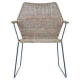 Natural rattan chair with an angled design, featuring a woven seat and backrest, supported by sleek metal legs. The chair has armrests and a light, neutral color that complements various decor styles