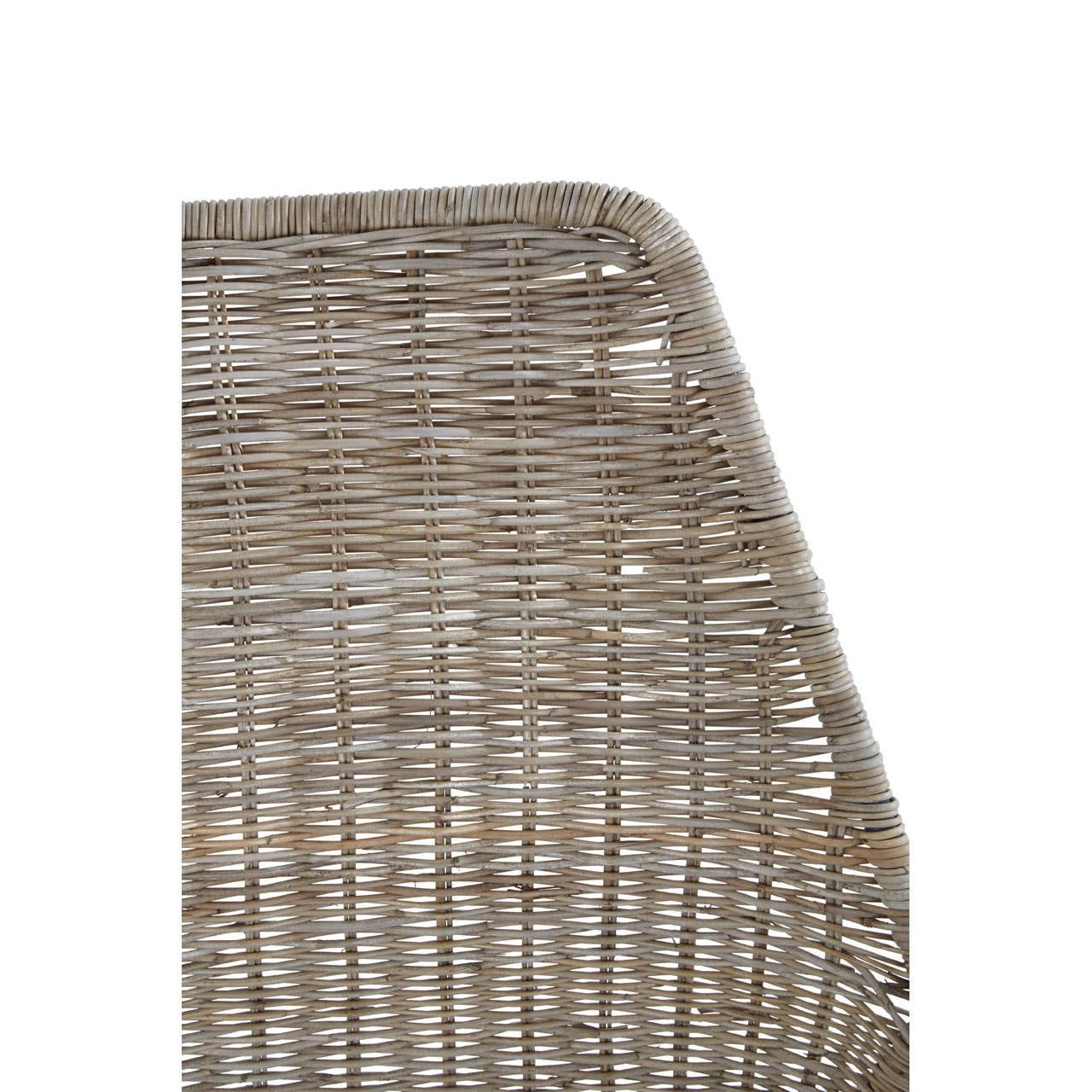 Close-up view of the angled design of a natural rattan chair, showcasing the textured weave and the smooth, curved edge. The chair features a neutral color palette that highlights the natural fibers