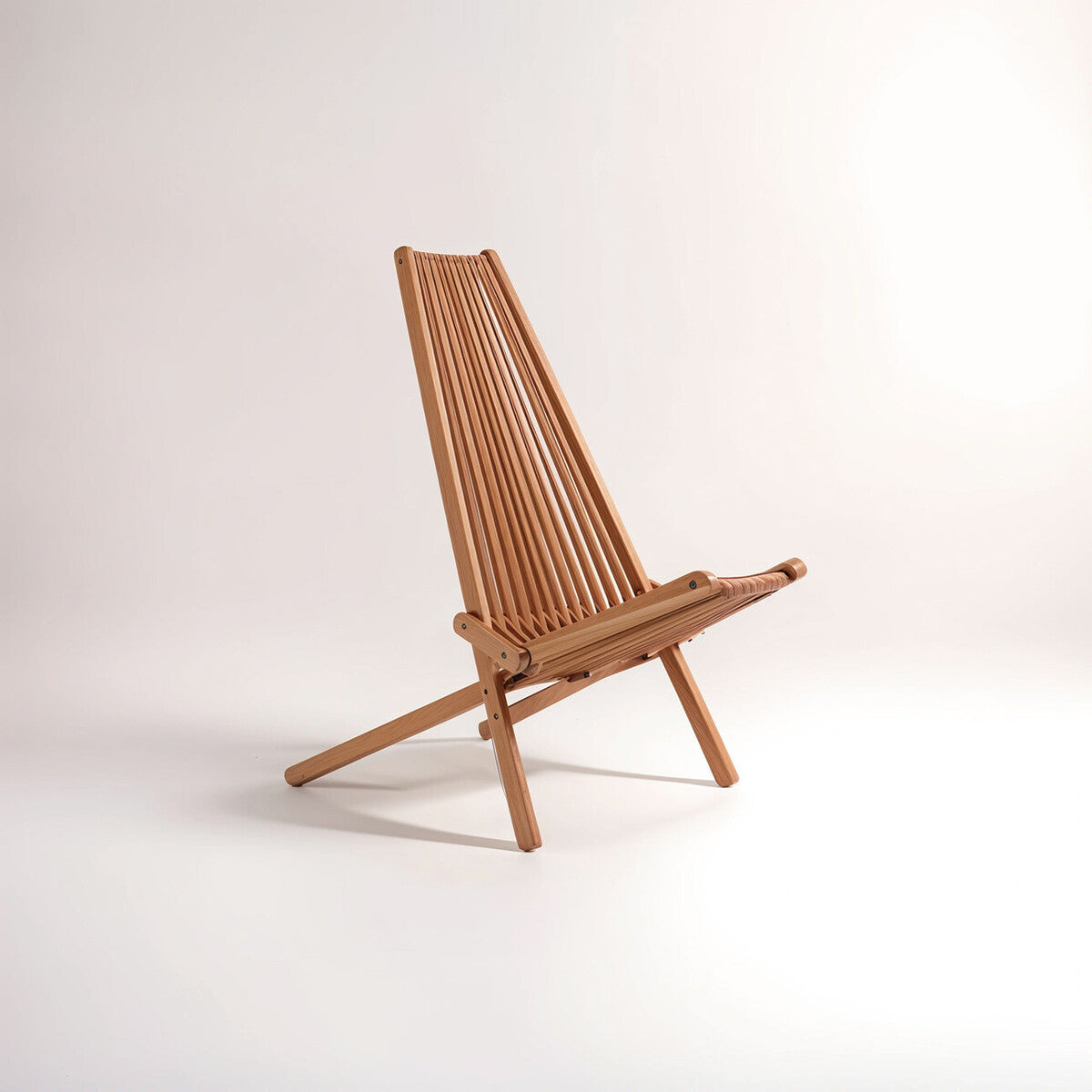 A wooden lounge chair with a tall, slatted backrest and a minimalist design, featuring a natural wood finish and angled legs for stability, set against a plain light background