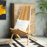 A wooden lounge chair with a slanted backrest and a light natural finish, featuring a white cushion on the seat. The chair is positioned next to a wooden cabinet against a textured wall, with a plant in the background and a patterned rug on the floor