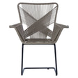 A stylish chair featuring a rattan effect design with a geometric pattern on the backrest, supported by a sleek black metal frame. The chair has wide armrests and a modern, open structure, suitable for both indoor and outdoor settings