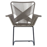 A stylish chair featuring a rattan effect design with a geometric pattern on the backrest, supported by a sleek black metal frame. The chair has wide armrests and a modern, open structure, suitable for both indoor and outdoor settings