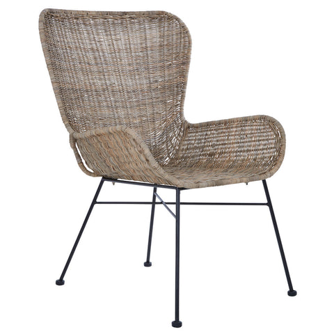 Curved design chair made of natural rattan with a light brown finish, featuring a wide backrest and armrests, supported by slender black metal legs