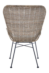 Curved back of a natural rattan chair showcasing a woven texture, supported by slender metal legs. The chair's design emphasizes a modern aesthetic with a natural finish