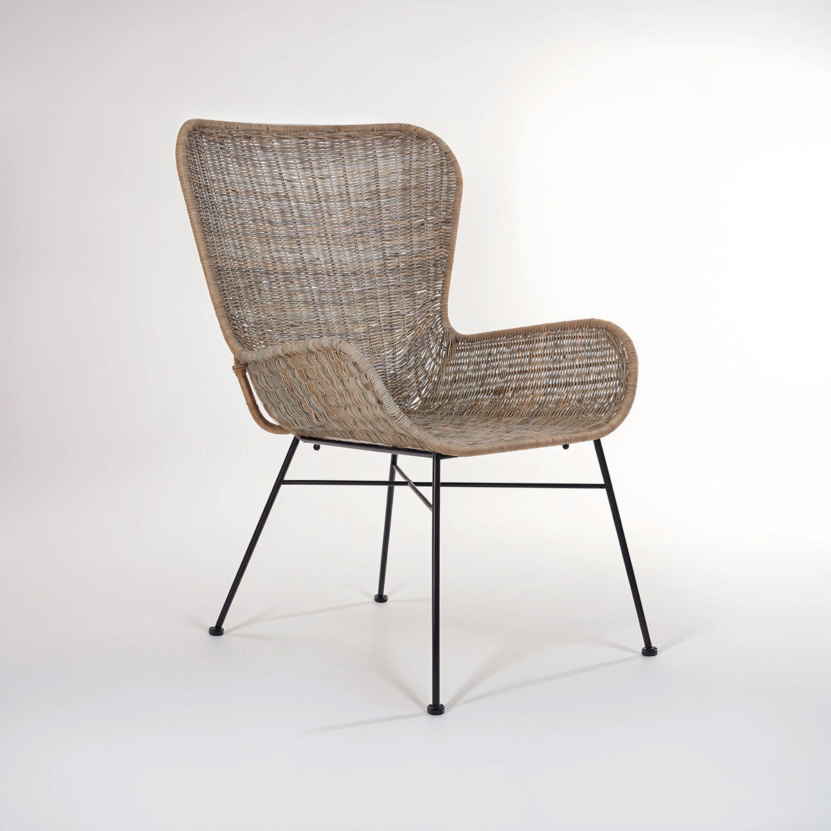 Curved design natural rattan chair with a light brown woven seat and backrest, supported by slender black metal legs, showcasing a modern and stylish aesthetic suitable for home decor