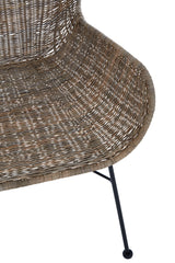Curved seat of a natural rattan chair with a textured surface, supported by slender black metal legs. The design showcases a warm, earthy tone and a modern aesthetic suitable for home decor