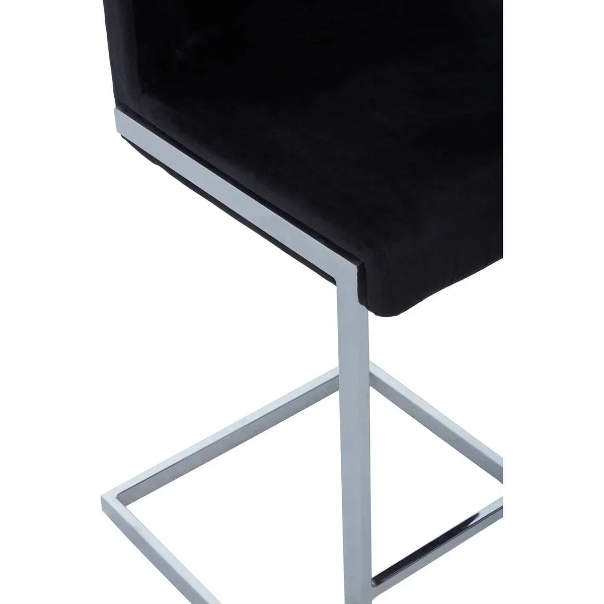 Black velvet dining chair with chrome metal leg frame, close-up of seat and base