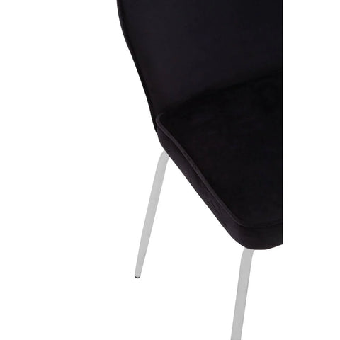 Black velvet dining chair with chrome legs, partial close-up of seat and back