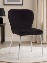 Black velvet dining chair with chrome legs on light rug in modern room setting
