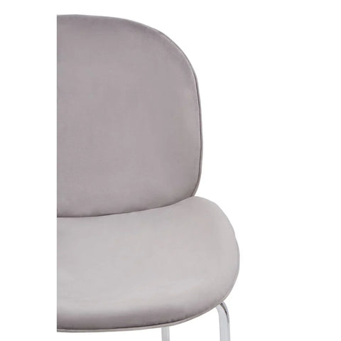 Close-up of grey velvet dining chair with chrome legs