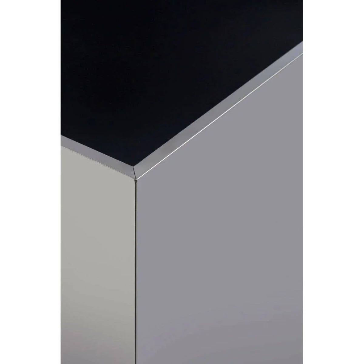Close-up of corner on modern chrome and black glass coffee table