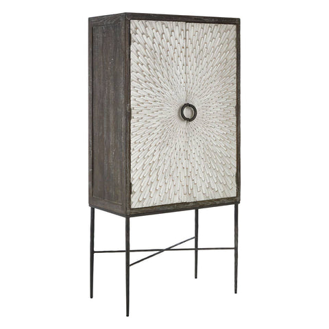 Milan Two Door Elm Wood Wine Cabinet featuring a textured front with a circular handle, standing on slender metal legs, showcasing a modern design with a natural wood finish
