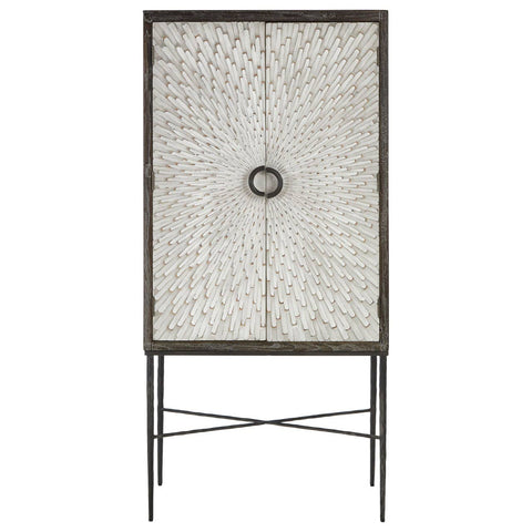 Milan Two Door Elm Wood Wine Cabinet featuring a textured front with a circular handle, supported by slender metal legs in a crossed design. The cabinet has a natural wood finish, showcasing the grain of the elm wood