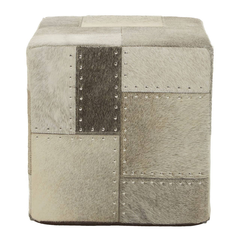 Square pouffe featuring a patchwork design in various shades of grey and beige, with visible stitching details. The surface appears soft and textured, suitable for use as a footrest or additional seating