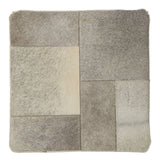 Square pouffe featuring a patchwork design in various shades of grey, with soft textures and a contemporary aesthetic, suitable for home decor