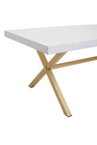 A white wash mango wood dining table featuring a smooth rectangular top and a sturdy, crossed wooden base in a natural finish. The design emphasizes clean lines and a modern aesthetic, suitable for various dining spaces