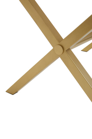 Close-up view of the cross-legged base of a dining table made from white wash mango wood, showcasing the natural grain and texture of the wood. The legs are positioned in an X shape, providing stability and a modern aesthetic