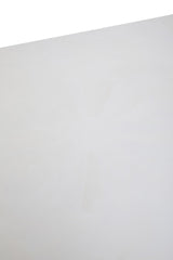 A close-up view of the surface of a white wash mango wood dining table, showcasing a smooth, light-colored finish with subtle wood grain patterns. The edges are slightly rounded, enhancing the table's modern aesthetic