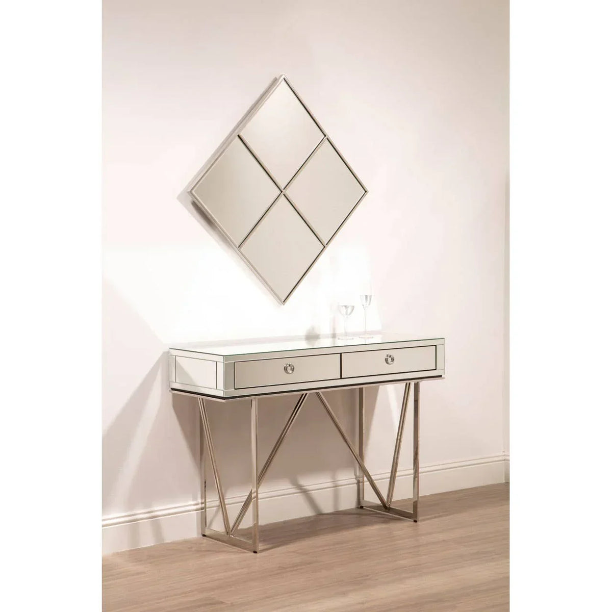 Mirrored console table with two drawers and geometric legs, wall mirror above, on wood floor