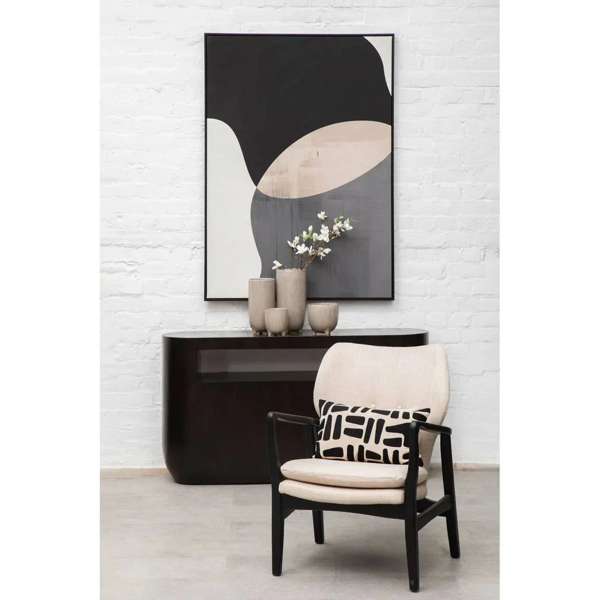 Modern accent chair with cream upholstery, black frame, and geometric cushion in living room
