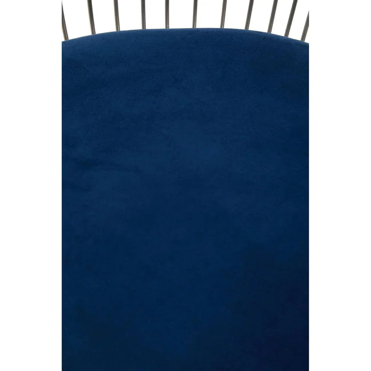 Close-up of blue velvet dining chair backrest with metal spindles