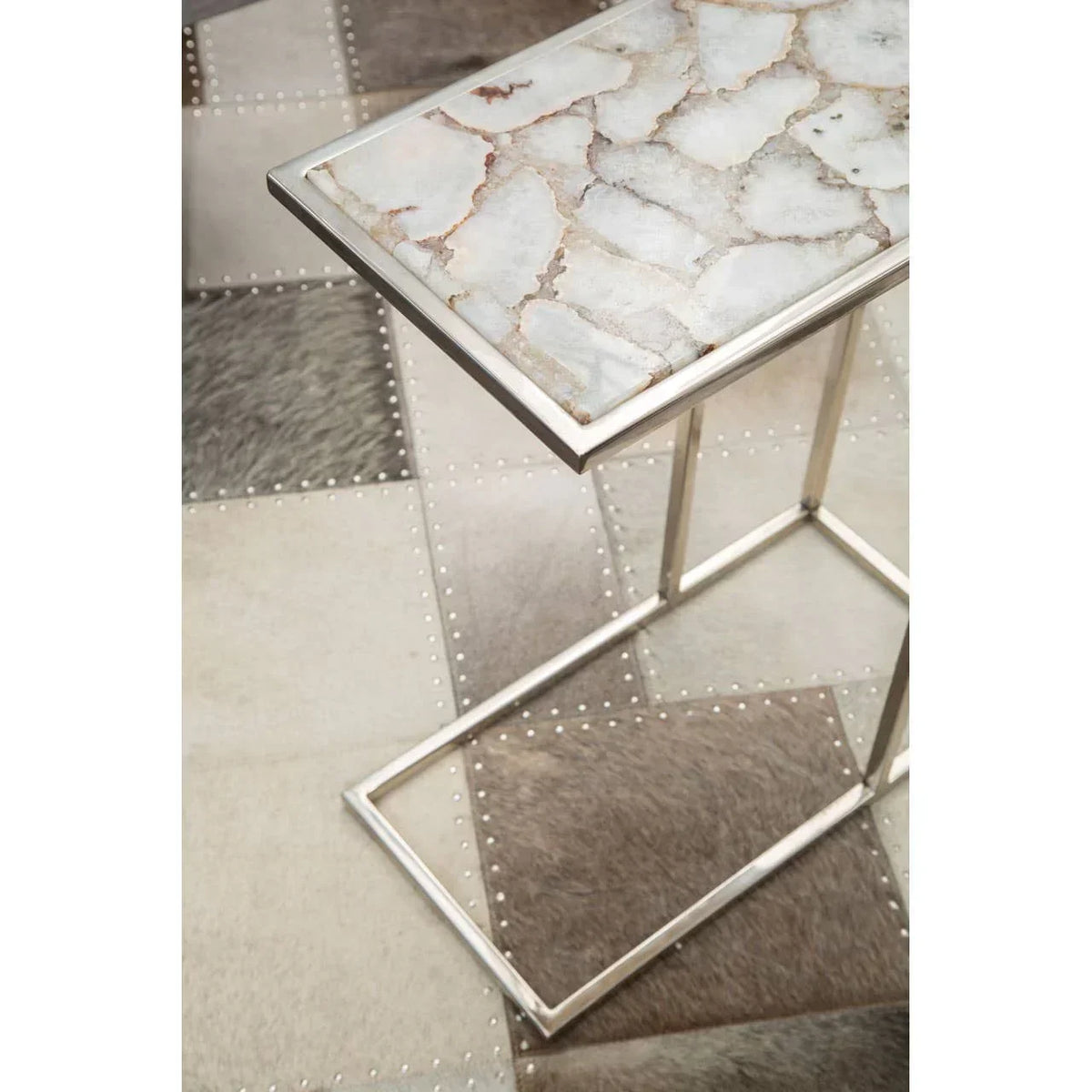Modern side table with marble top and metal frame on patchwork patterned rug