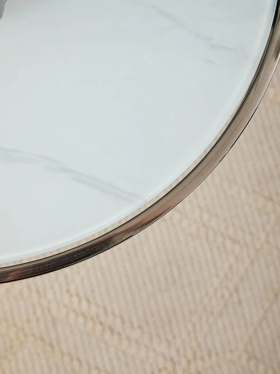 Round marble coffee table top with metal edge on textured beige rug