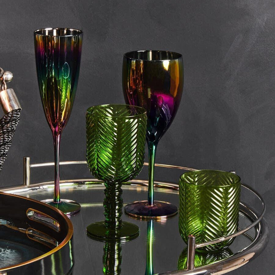 Green textured glassware and iridescent wine glasses on mirrored drinks trolley