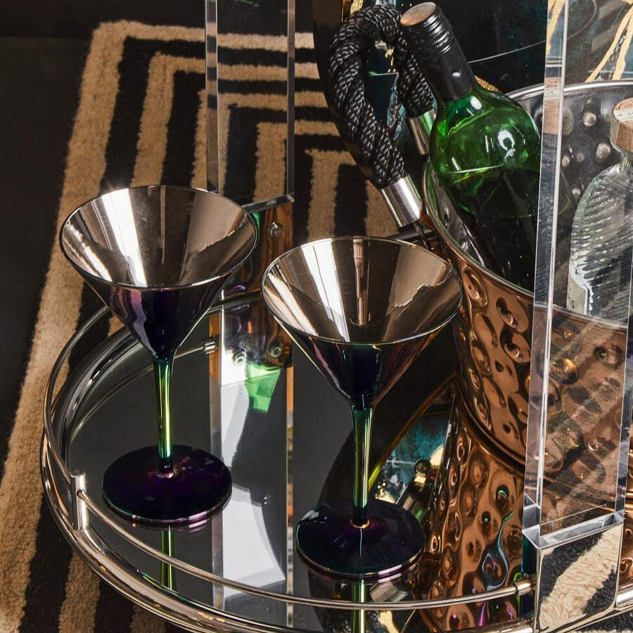 Glass and chrome drinks trolley with two martini glasses and a wine bottle on mirrored tray