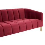 A plush, three-seat sofa upholstered in rich wine-colored velvet, featuring vertical channel tufting on the backrest and seat cushions. The sofa has sleek, angled armrests and stands on elegant, tapered wooden legs