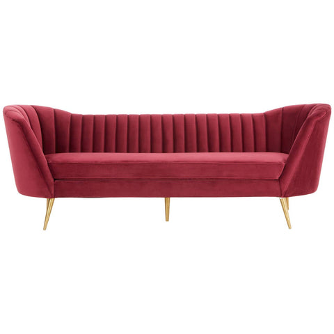 Three-seat sofa upholstered in rich wine-colored velvet, featuring a channel-tufted backrest and sleek, angled arms. The sofa stands on slender gold metal legs, adding a touch of elegance to its modern design