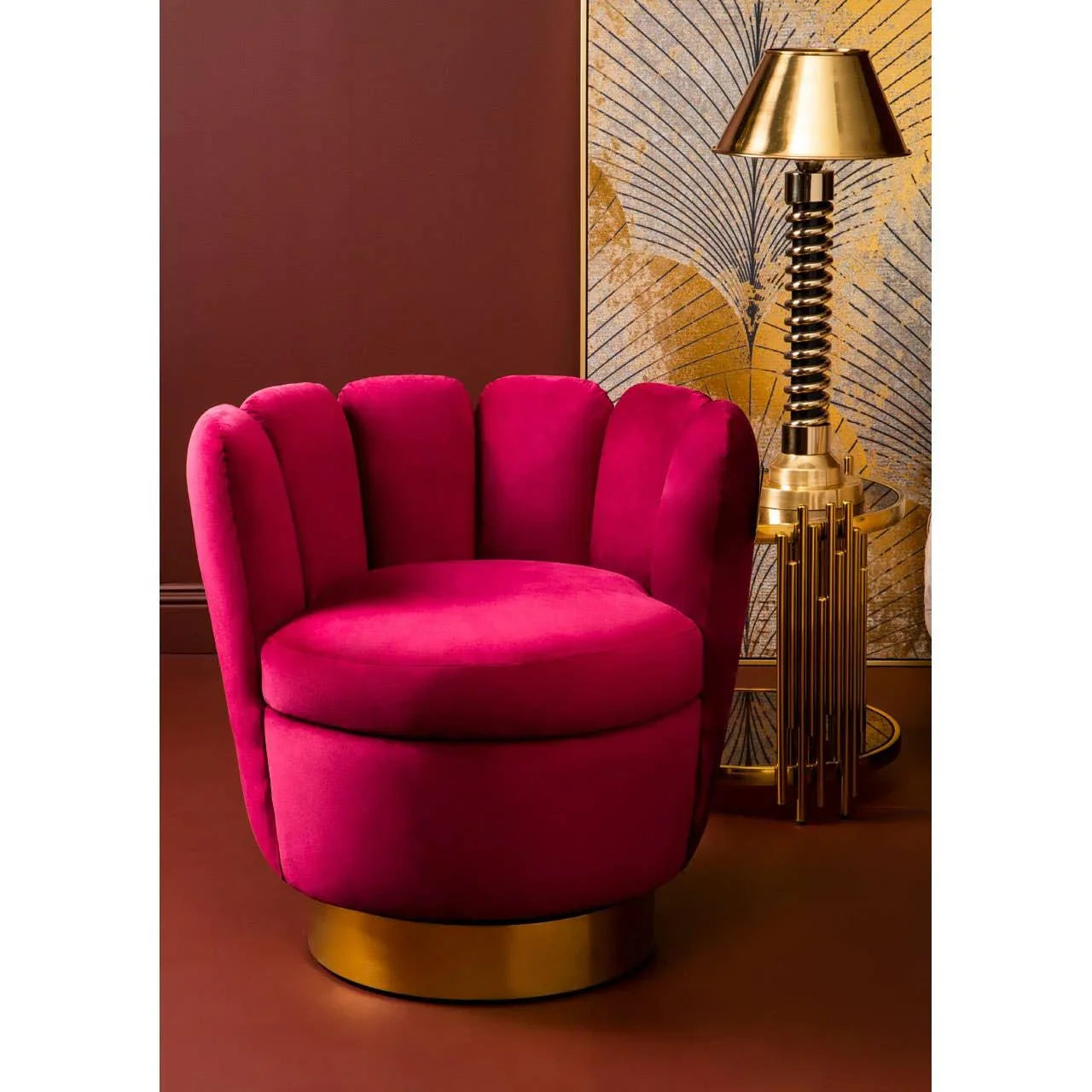 Fuchsia velvet accent chair with gold base beside gold table lamp in modern living room