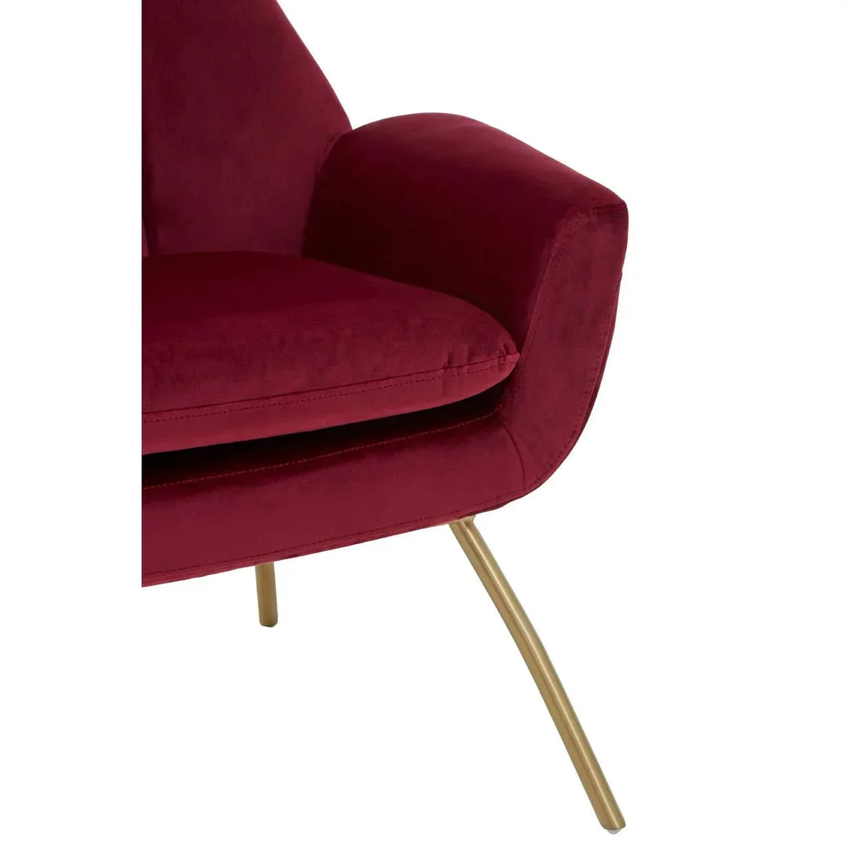 Velvet accent chair in red with gold metal legs, close-up of armrest and seat cushion