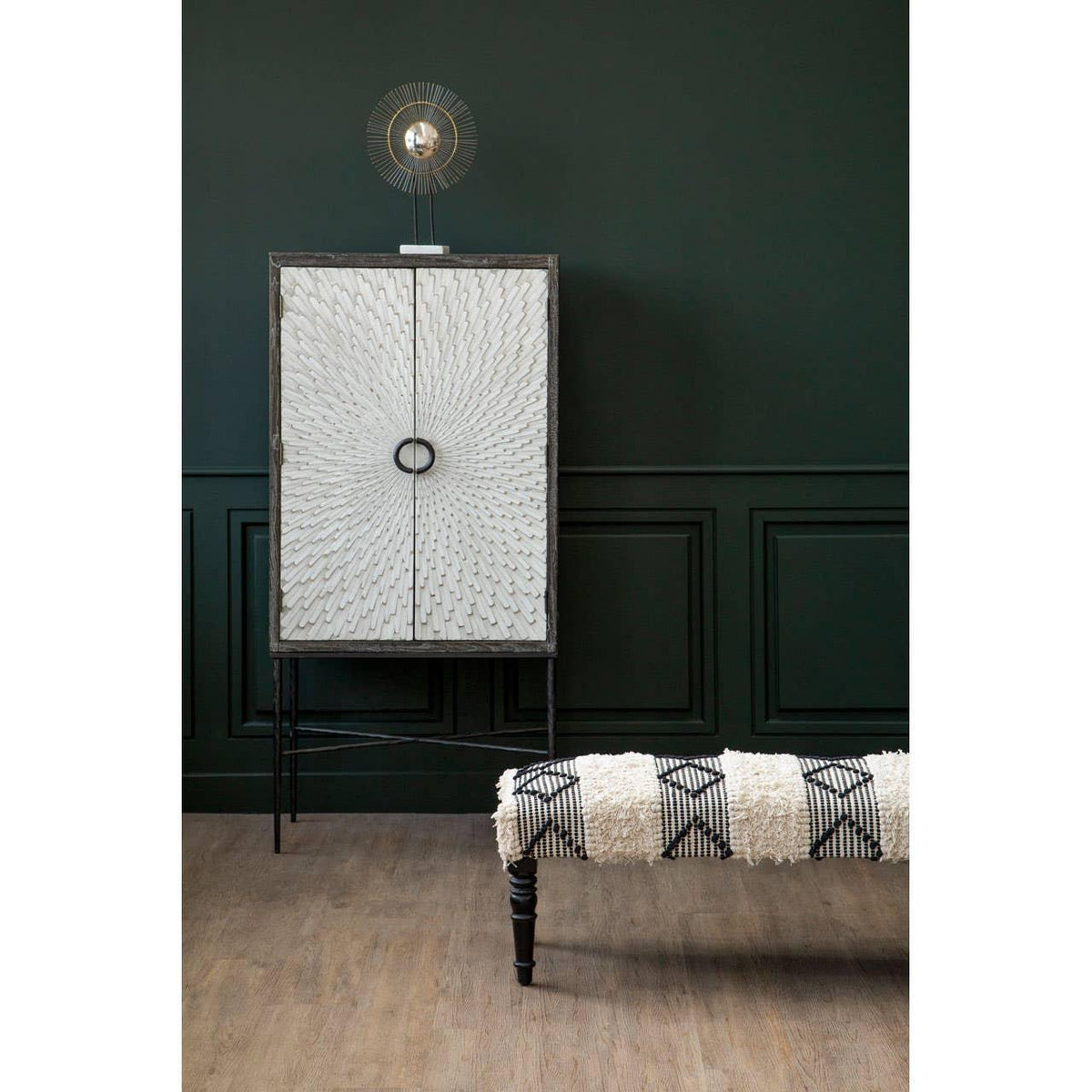 White textured wooden cabinet with circular handles beside patterned upholstered bench