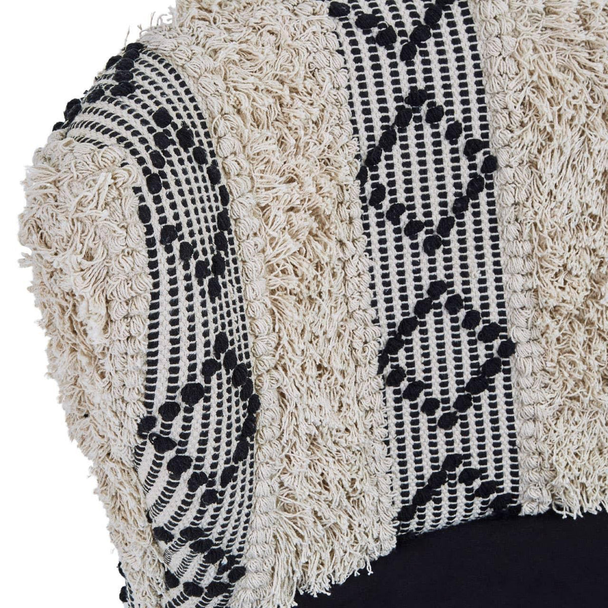 Textured cream and black patterned cushion cover close-up with woven fringe detail