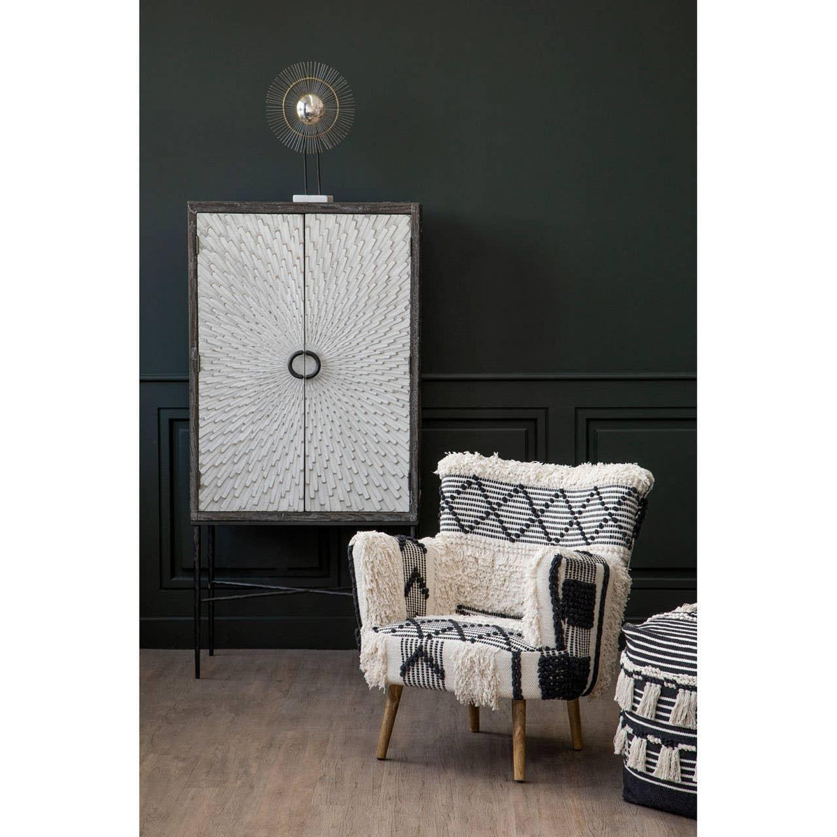 Textured accent cabinet with geometric pattern beside black and white armchair