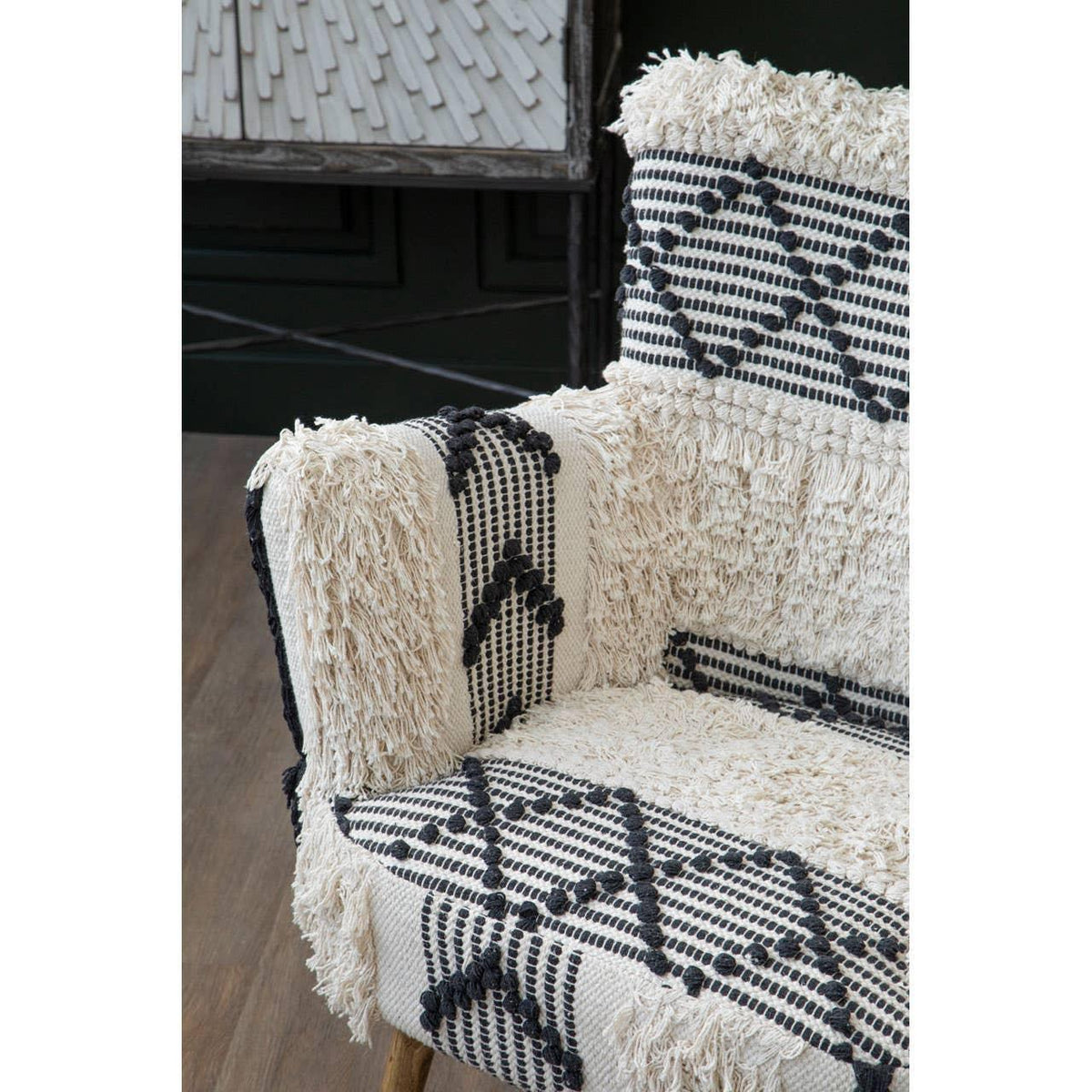 Textured armchair with cream and black geometric upholstery on wooden floor