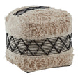 Shaggy pouffe featuring a textured beige top and a black and white woven band around the middle, with a cube shape and soft, fluffy surface