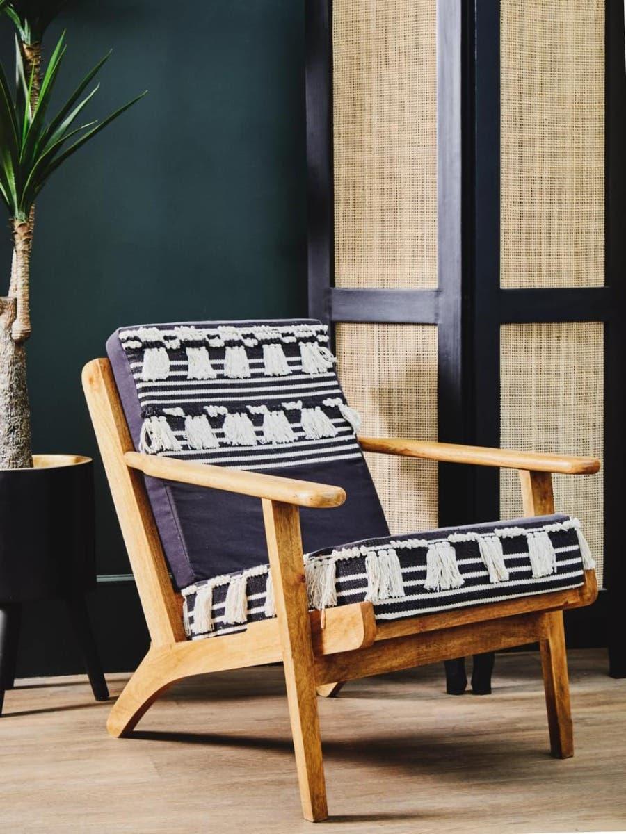 Wooden armchair with striped black and white cushion in modern living room setting