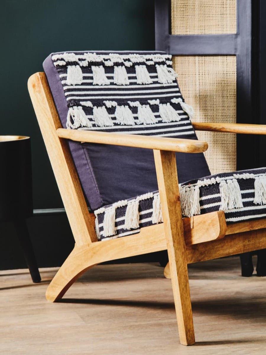 Wooden armchair with navy and cream striped woven cushion and tassel accents